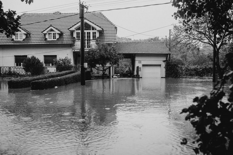 Загородный дом, окружённый водой после ливня и подтопления участка