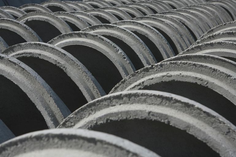 Стопка бетонных колец, из которых собирают шахту дренажного колодца