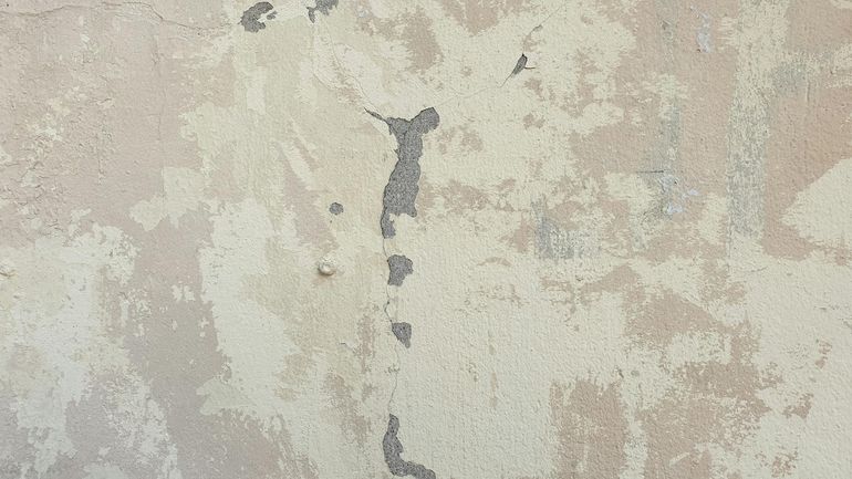 Стена с трещинами и отслаивающейся штукатуркой как следствие ошибок проектирования