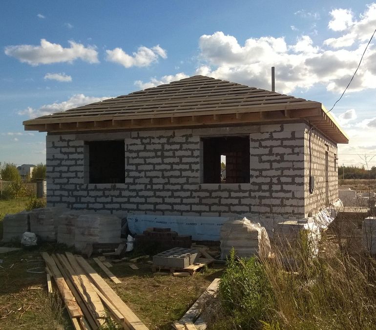 Строящийся частный дом с голыми стенами перед этапом утепления фасада