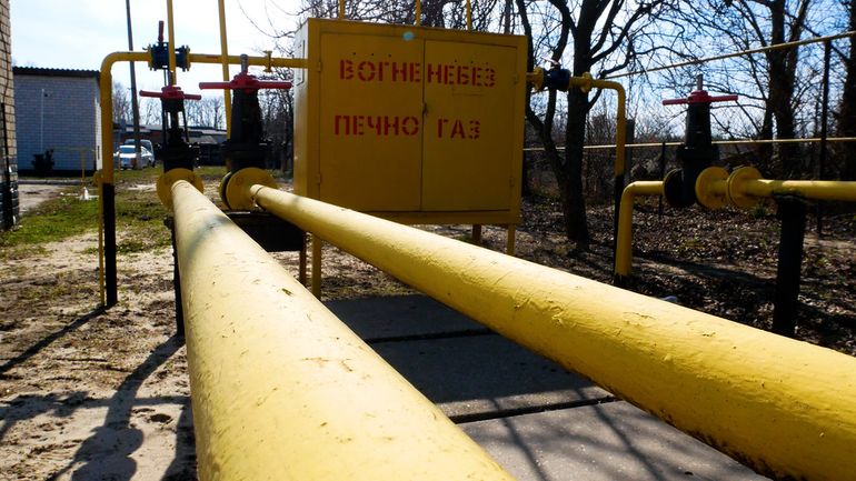 Жёлтая газовая труба с запорным краном возле дома