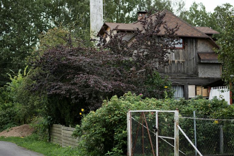 Деревенский дом с деревянным забором и садом за ограждением участка