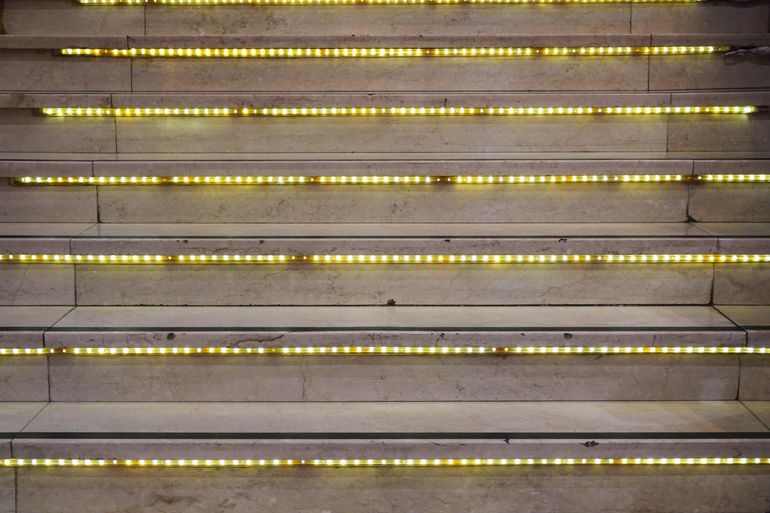Тёмная лестница со встроенной LED-подсветкой каждой ступени вечером