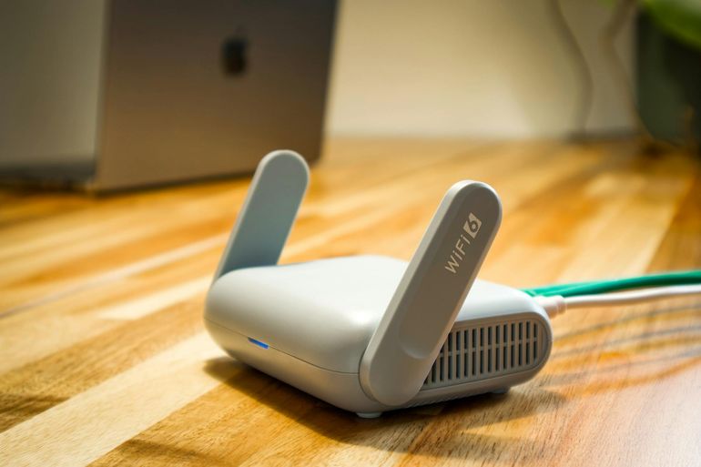 Современный Wi-Fi роутер с антеннами на деревянной поверхности в жилой комнате