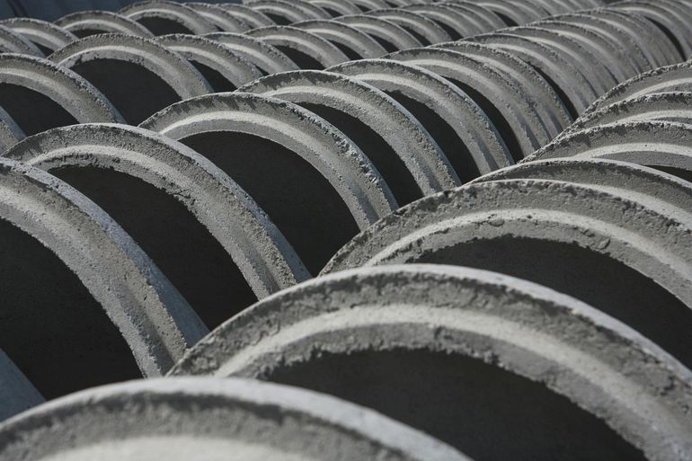 Стопка бетонных колец, из которых собирают шахту дренажного колодца