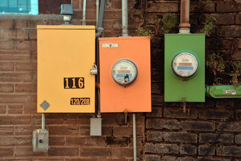 Три электросчётчика на кирпичной стене как метафора трёх отдельных фаз ввода