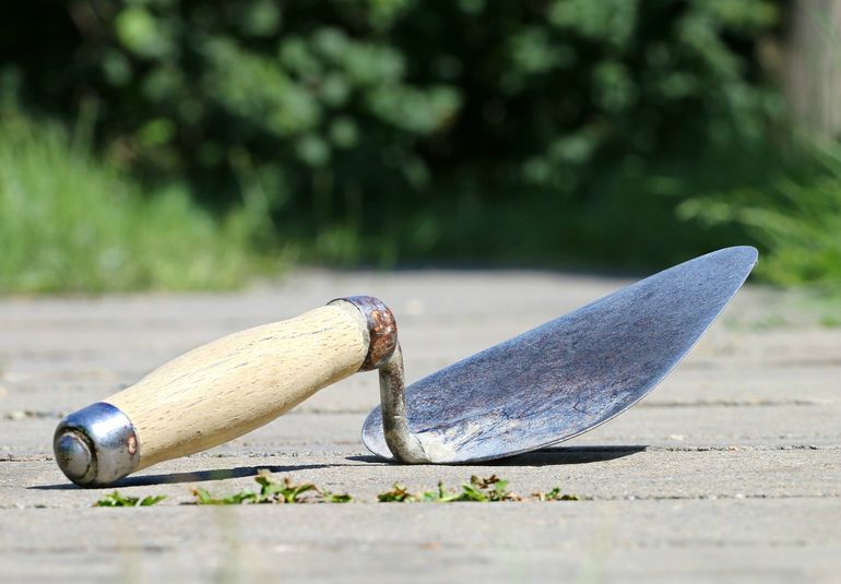 Шпатель в руке мастера у стены при нанесении шпаклёвочного слоя