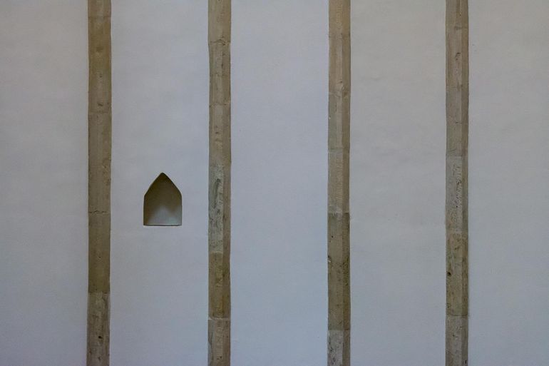 Стена с прямоугольной нишей между каменными колоннами в минималистичном интерьере