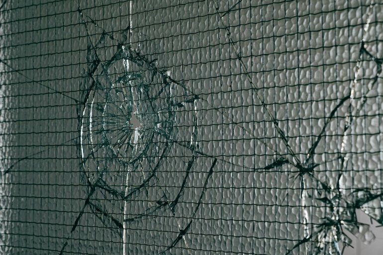 Треснувшее безопасное стекло удерживается плёнкой и не рассыпается на осколки