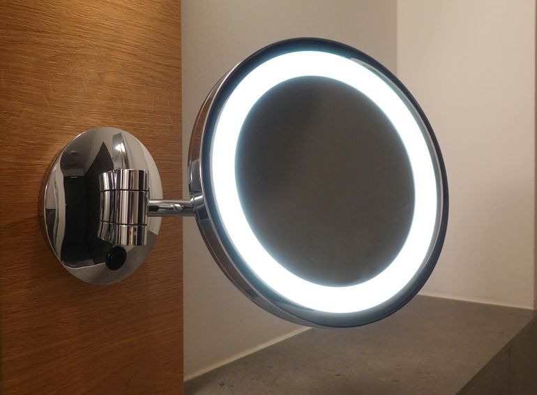 Хромированное зеркало с LED-подсветкой в современной ванной комнате у умывальника