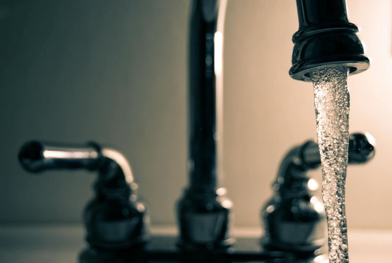 Струя воды из хромированного кухонного смесителя — проверка напора в точке водоразбора