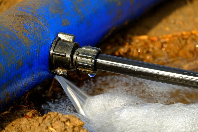 Подтекающая водопроводная труба с каплями воды на соединении