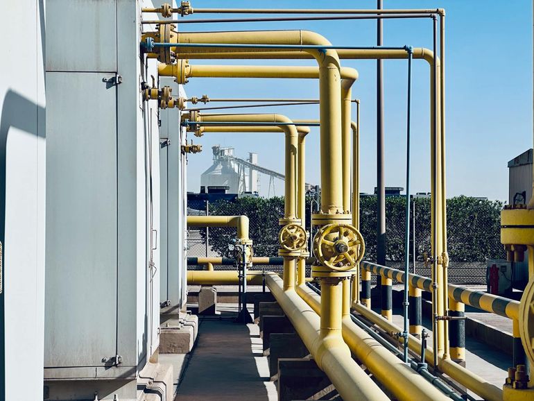 Металлические трубы и арматура промышленного газопровода с фланцами и отводами
