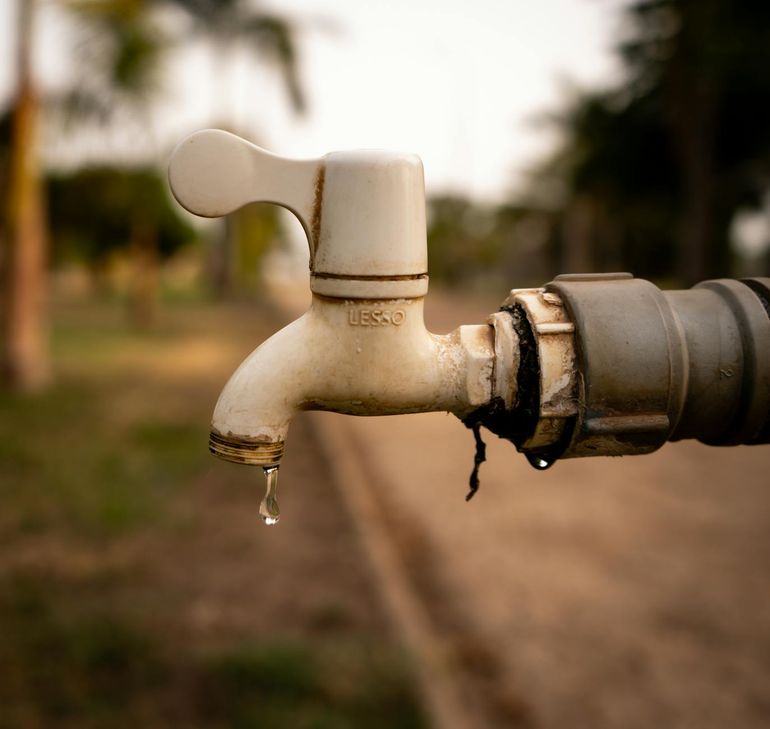 Капля воды срывается с крана крупным планом