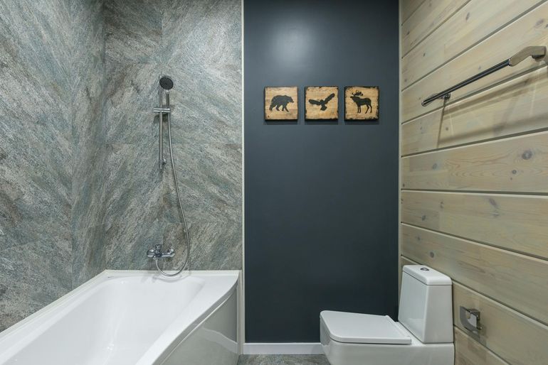 Современный санузел с плиткой на стенах, ванной и унитазом
