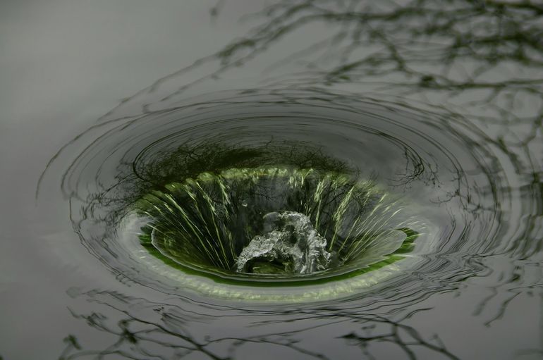 Воронка воды закручивается и уходит в сливное отверстие