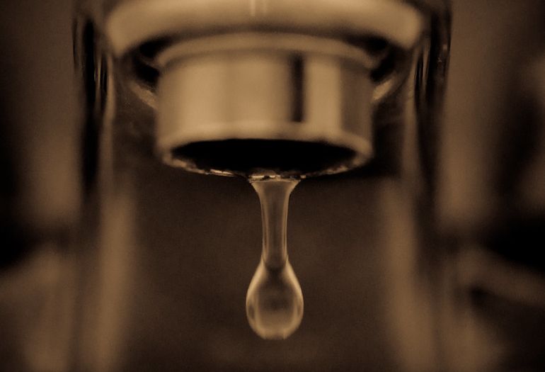 Капля воды на кончике крана — символ минимального потока в простаивающей трубе